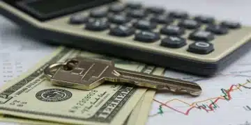 House key on dollar bills with rising interest rate graph